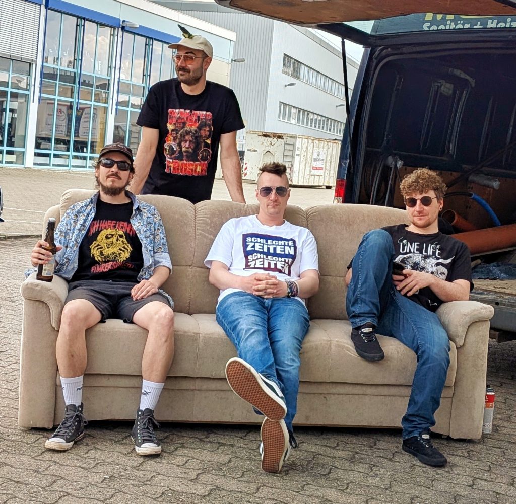 Sofaritze - Bandmitglider
"4 Personen auf Sofa vor VAN"